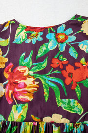 Embroidered floral babydoll blouse with a ruffled hem and round neckline.