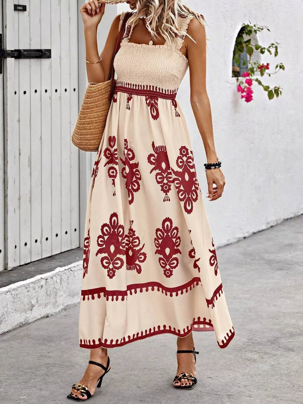 Maxi dress with smocked bodice, square neck, and bold red pattern on tan fabric.