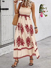 Maxi dress with smocked bodice, square neck, and bold red pattern on tan fabric.