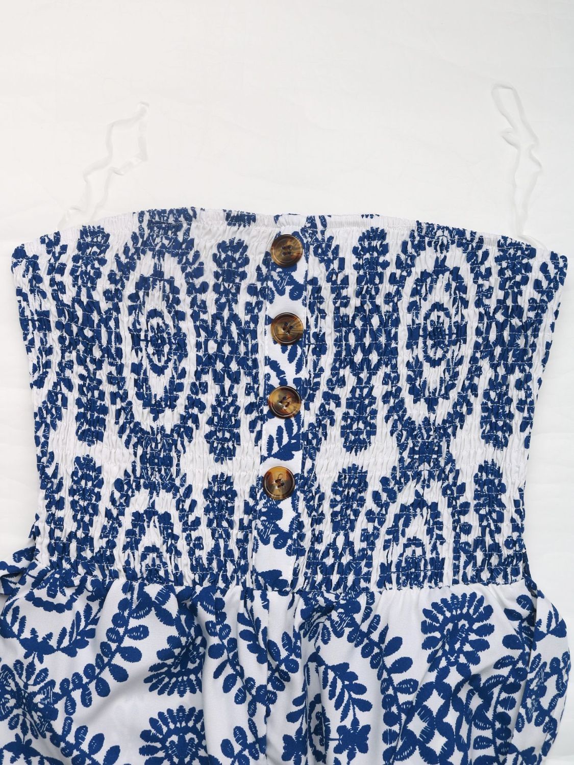 Blue bustier jumpsuit with white floral print and decorative buttons