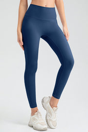 Dark blue high rise leggings with a smooth finish, worn with white sneakers.