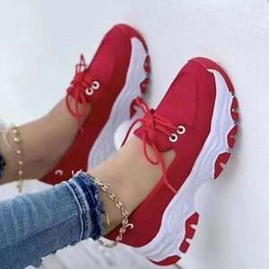 Red lace-up sneakers with white chunky soles and round toes.