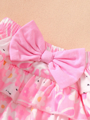 Pink ruffled baby bodysuit and skirt set with floral print and bow detail.
