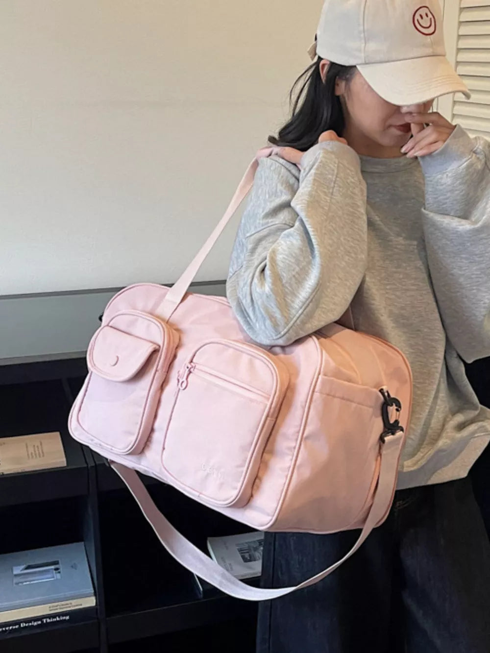 Pink nylon duffle bag with multiple pockets and adjustable strap