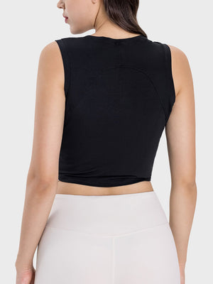 Black asymmetric ruched crop tank top with curved seam detail on back.
