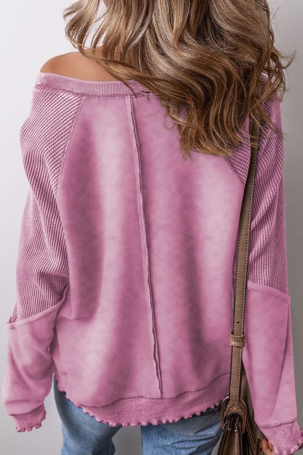 Dusty pink waffle knit sweatshirt with raglan seams and contrast textured sleeves.