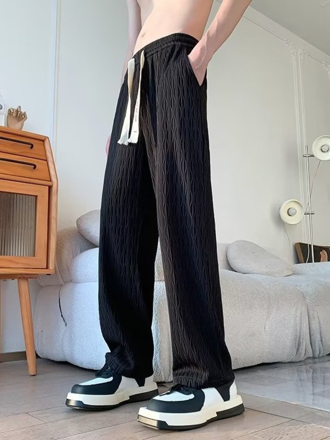 Black textured wide-leg drawstring sweatpants with a relaxed fit.