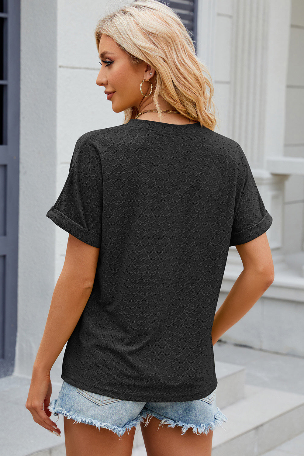 Black textured henley tee with rolled sleeves and a buttoned placket.