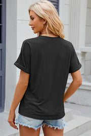 Black textured henley tee with rolled sleeves and a buttoned placket.