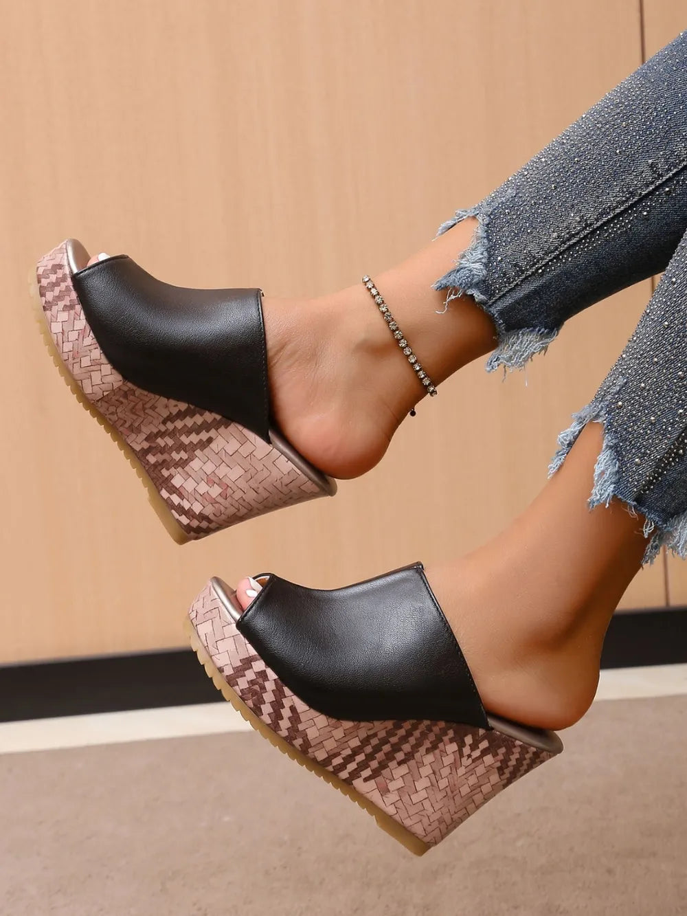 Black textured wedge mules with open toe and woven platform.