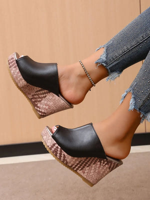 Black textured wedge mules with open toe and woven platform.