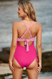 Ribbed fuchsia pink one-piece swimsuit with tie back detail and side ties.