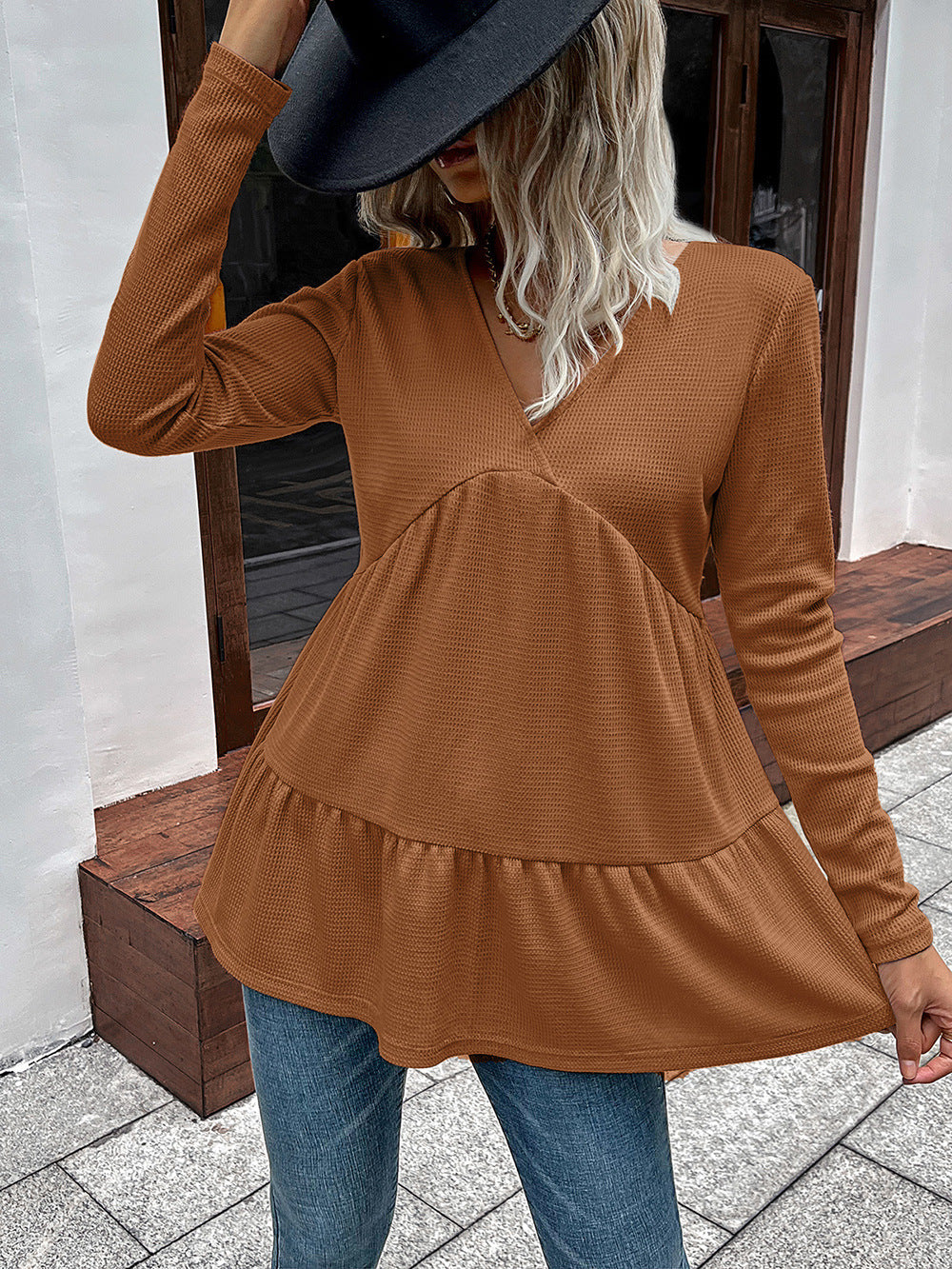 Caramel waffle knit peplum top with V-neck and long sleeves.