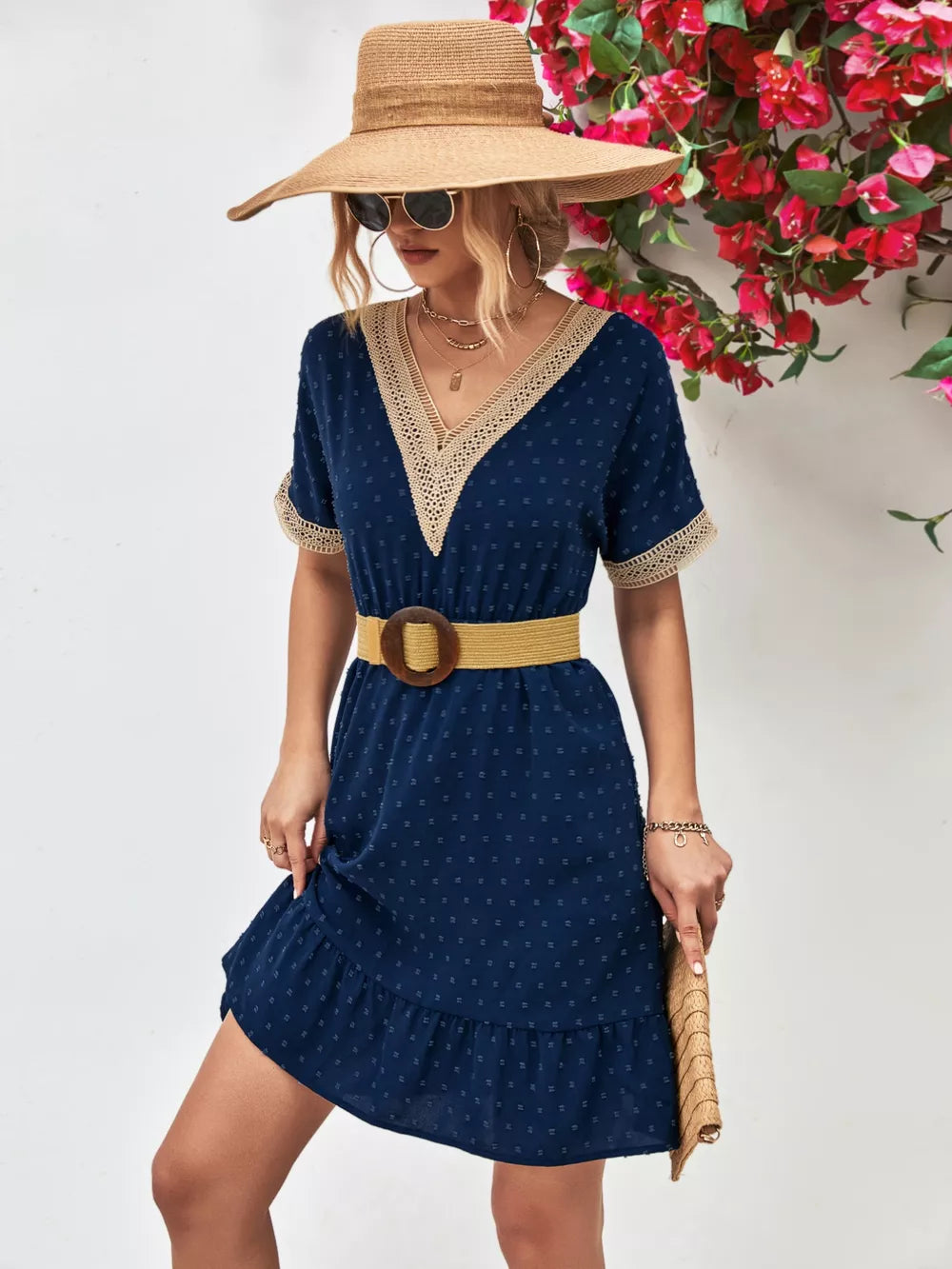 Navy Swiss dot mini dress with V-neck, lace trim, short sleeves, and ruffled hem.