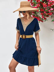 Navy Swiss dot mini dress with V-neck, lace trim, short sleeves, and ruffled hem.