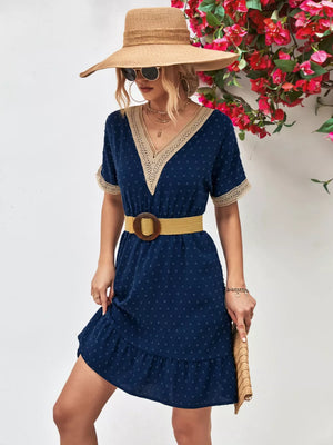 Navy Swiss dot mini dress with V-neck, lace trim, short sleeves, and ruffled hem.