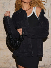 Black denim trucker jacket with collar, buttons, and chest pockets, styled with a black dress.