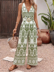 Botanical print halter neck jumpsuit with wide legs and a wooden buckle belt.