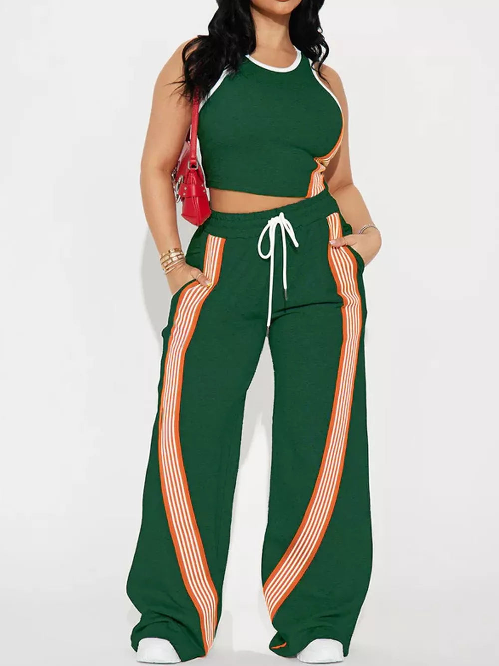 Green athletic-chic two-piece set with white trim and orange stripe details on cropped top and wide-leg pants.