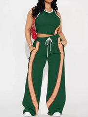 Green athletic-chic two-piece set with white trim and orange stripe details on cropped top and wide-leg pants.