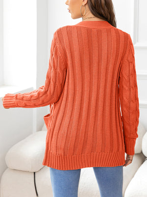 Orange acrylic cable-knit pocket cardigan with ribbed texture and open front.