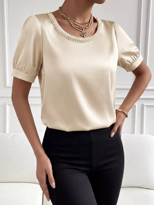 Pearl-trimmed satin bodysuit with short puff sleeves and a crew neckline.