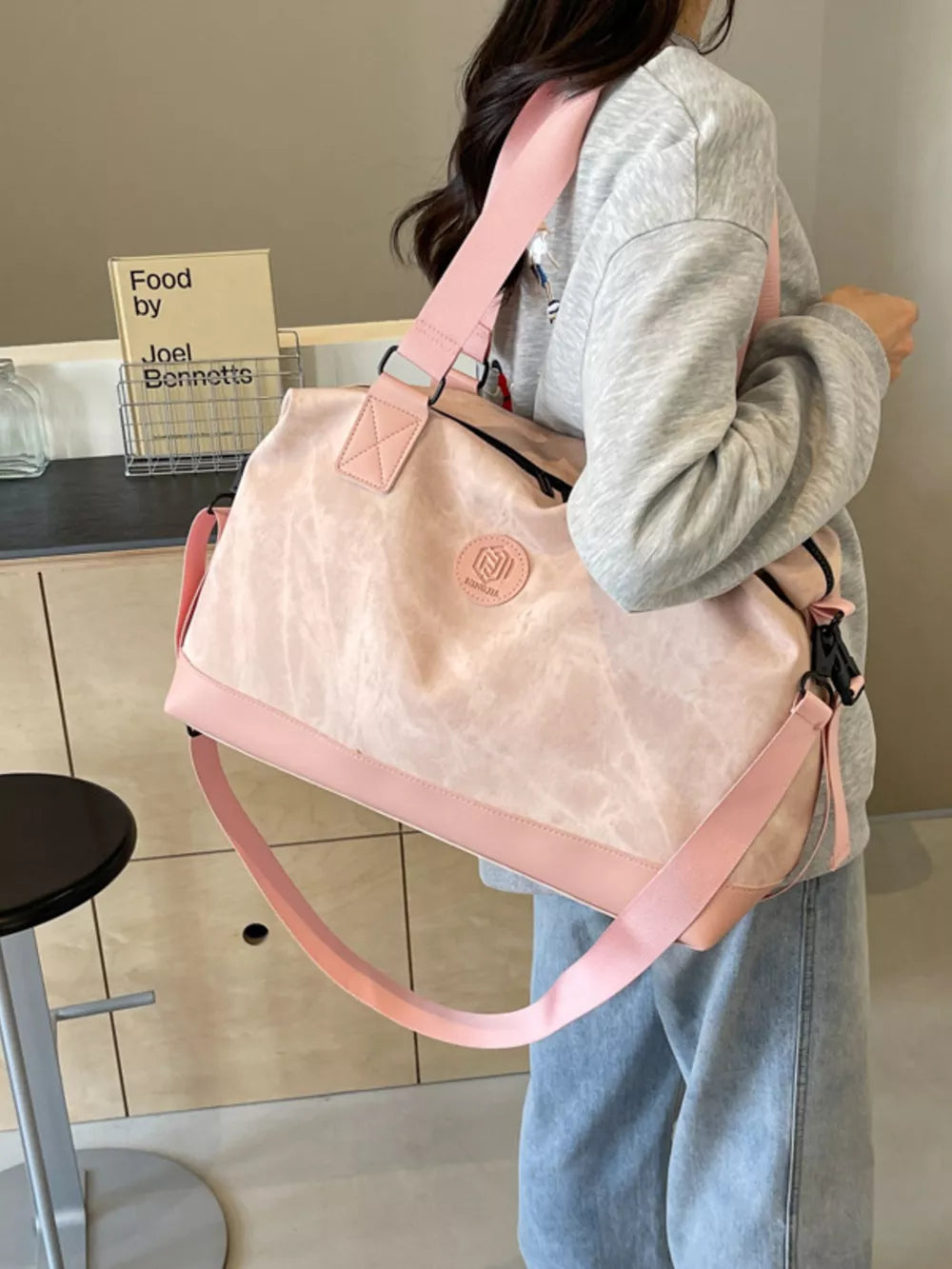 Pink distressed duffle bag with adjustable strap and pink trim