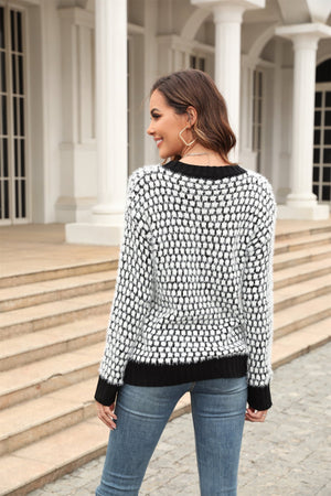Textured bouclé knit sweater with black contrast trim and a black and white pattern.