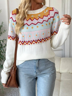 White geometric knit sweater with long sleeves and a crew neck, styled with jeans.