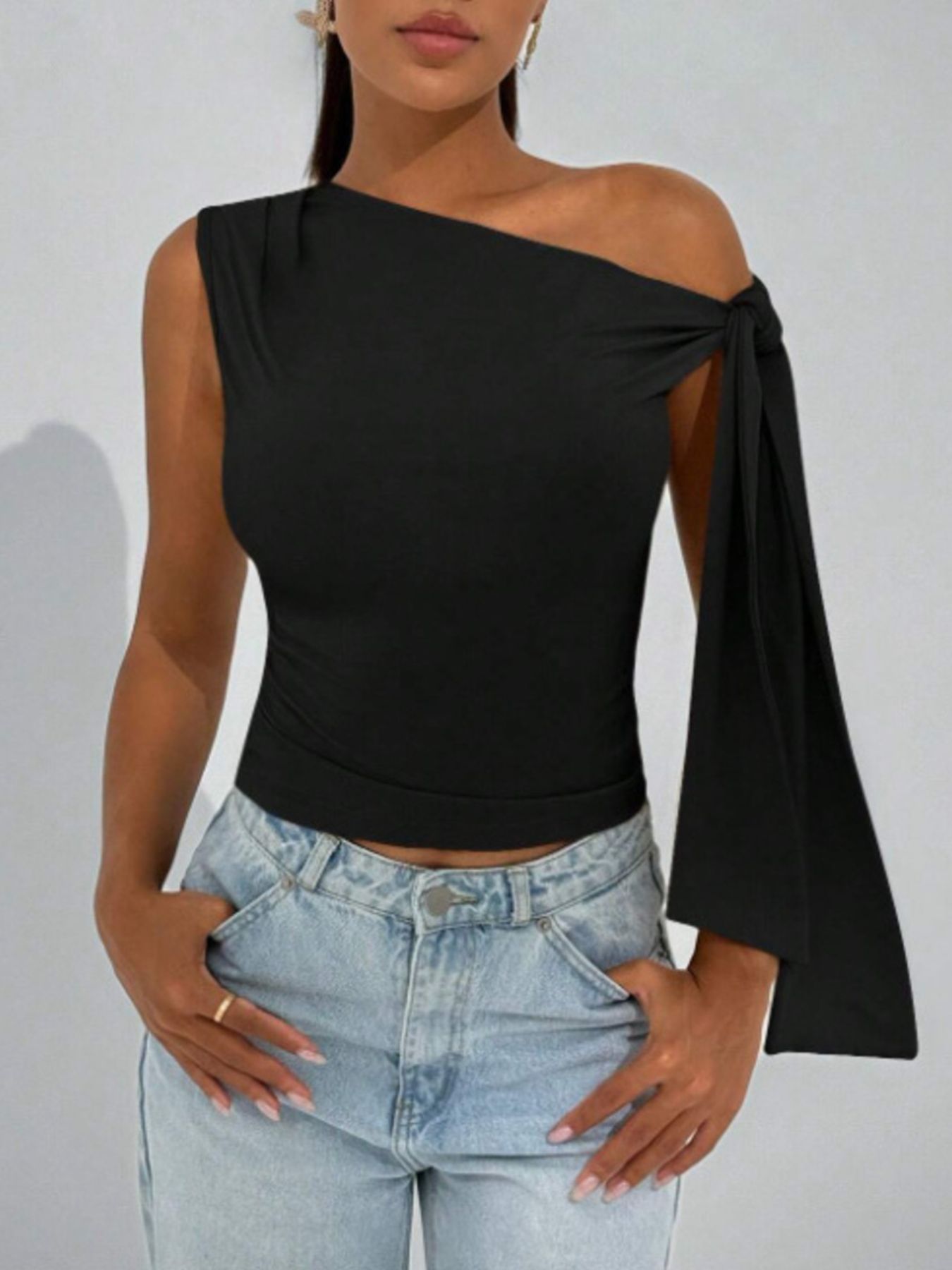 Black asymmetrical tie detail cropped blouse with one-shoulder neckline.