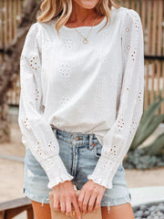 White cotton eyelet embroidered blouse with ruffled cuffs and long sleeves.