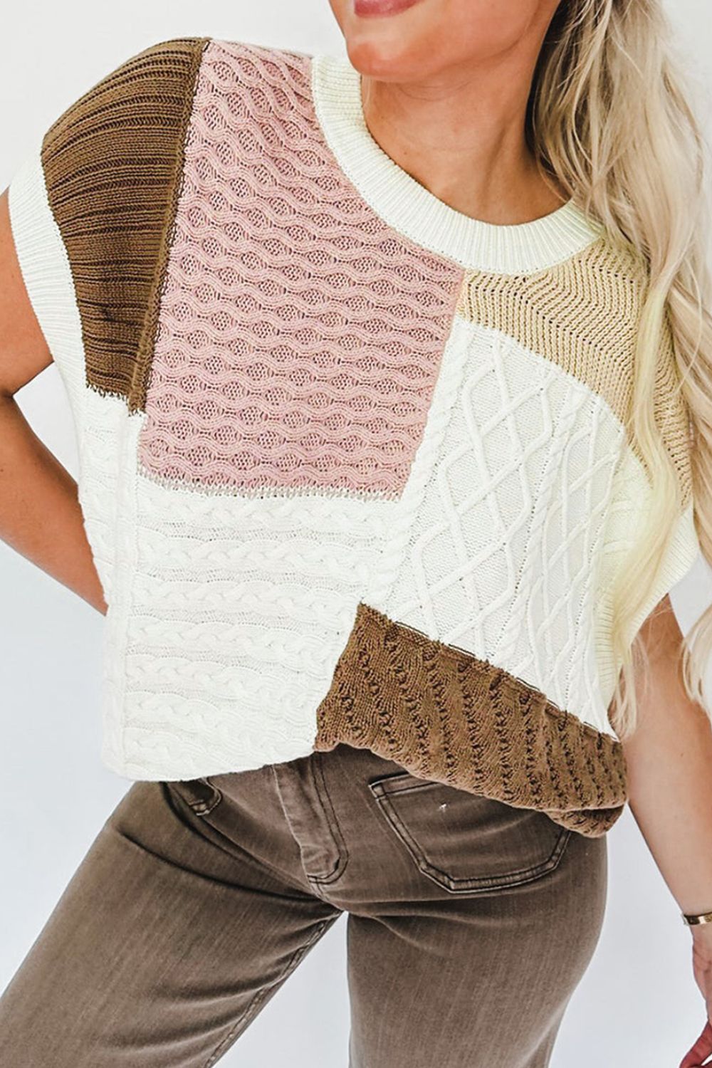 Patchwork cable knit tank top in dusty pink, white, brown, and beige with a crew neck and sleeveless design.