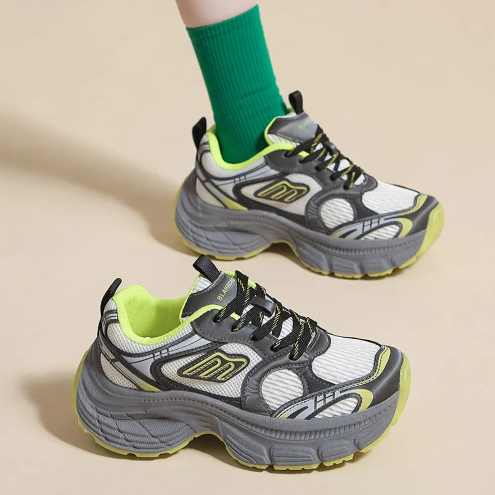 Chunky retro runner sneakers in white with grey and neon yellow accents, featuring a thick sole.