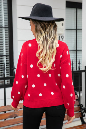 Red polka dot knit sweater with balloon sleeves and crew neck.
