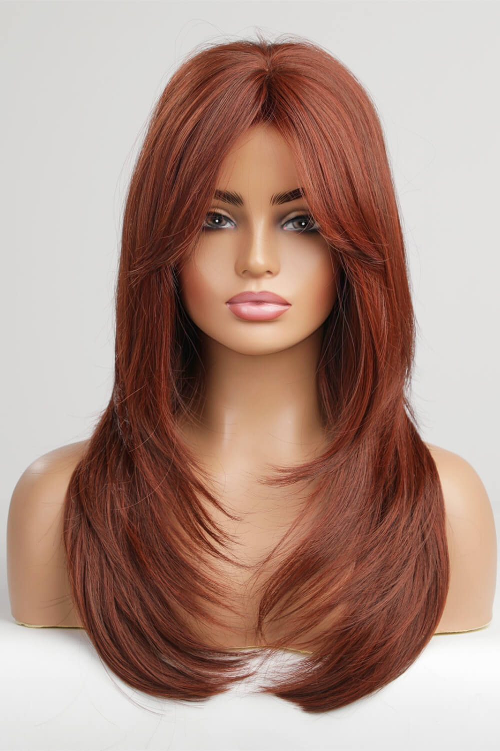 Layered copper red synthetic wig with chic bangs and face-framing layers.