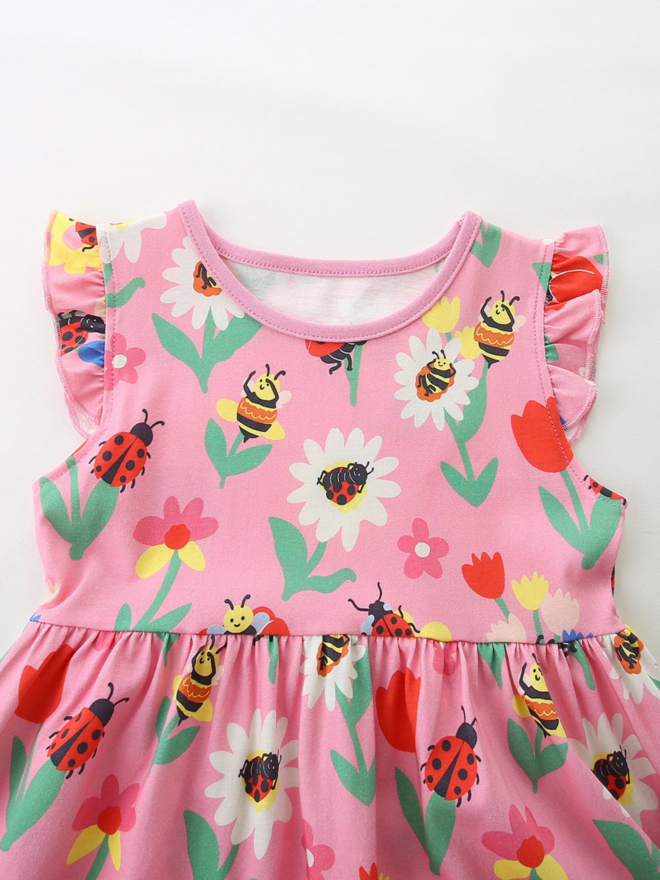 Toddler pink cotton dress with ruffle sleeves and a playful ladybug and bee floral print.