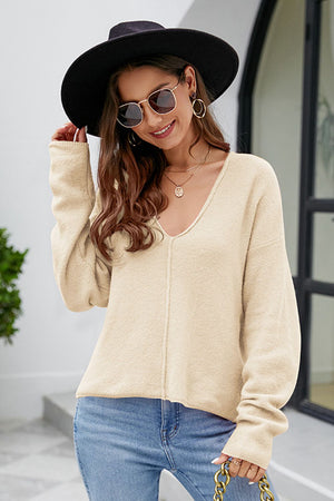 Tan textured knit pullover sweater with deep V-neck and seam detail.
