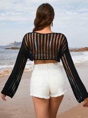 Black cropped crochet beach cover-up with long sleeves and open knit detail.