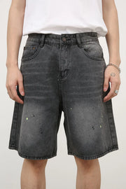 Dark wash denim bermuda shorts with artistic paint splatter detail