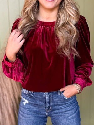 Burgundy velvet blouse with ruched neckline and puff sleeves.