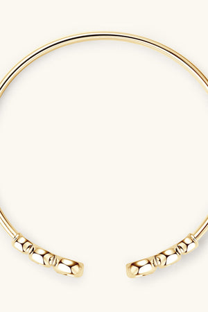 Gold open-ended cuff bracelet with faceted bead details