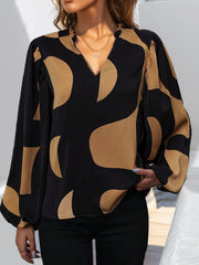 Black and tan geometric print blouse with voluminous sleeves and a V-neck.