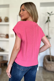 Cable knit cap sleeve pullover in strawberry pink with braided detail.