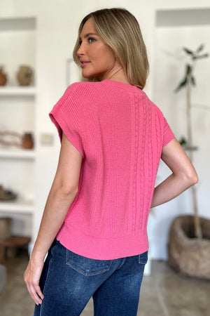 Cable knit cap sleeve pullover in strawberry pink with braided detail.