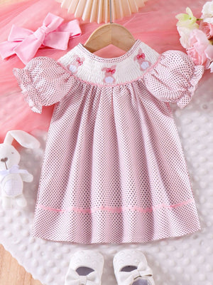 Pink polka dot baby dress with smocked neckline and embroidered bunnies, puff sleeves.