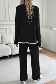 Black ribbed knit loungewear set with cream trim on cuffs and hem.