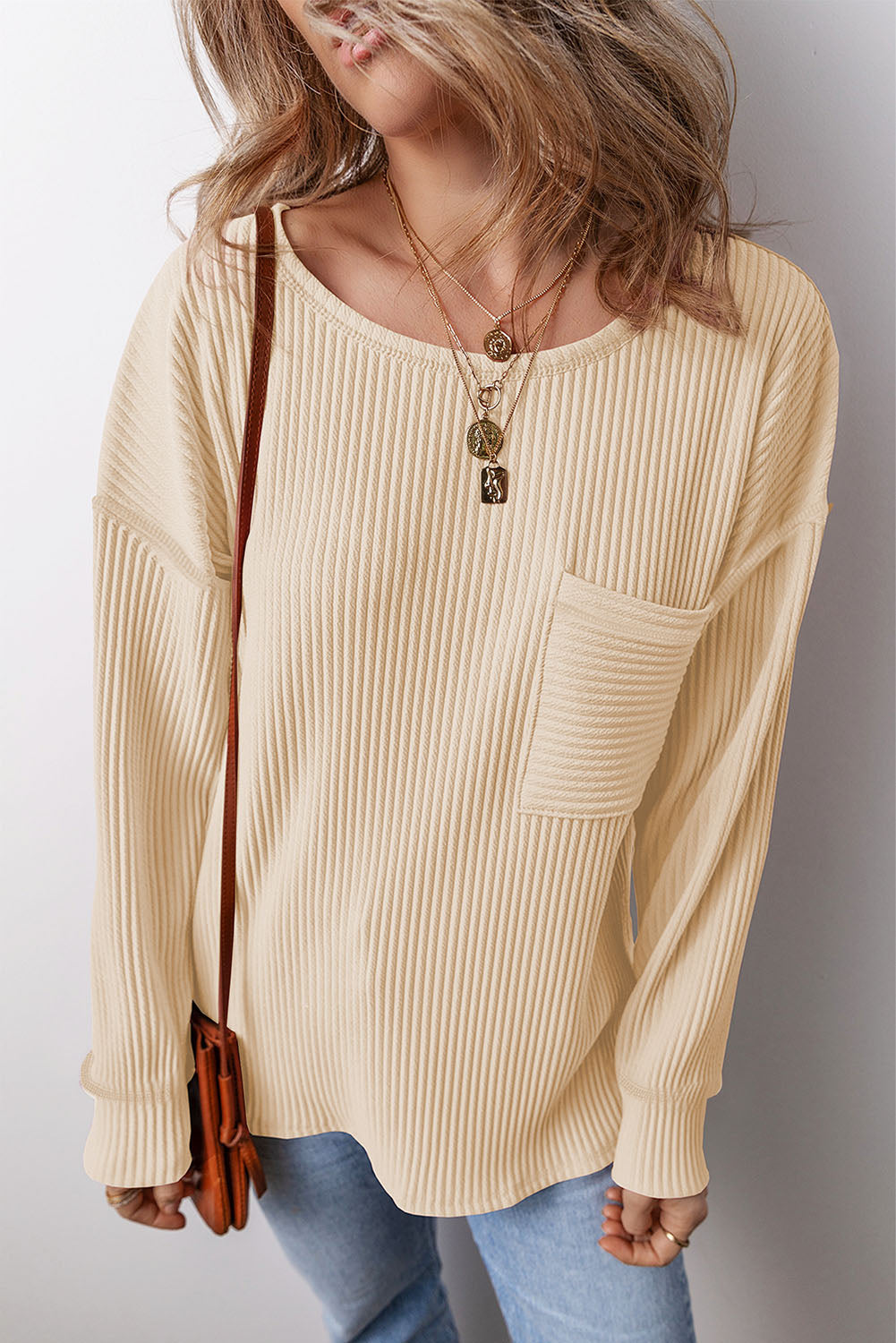 Ribbed knit tan long sleeve top with a patch pocket and crew neck.