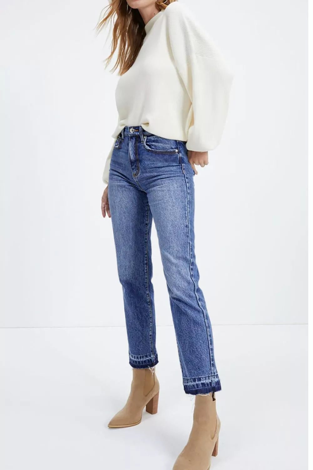 Blue cropped jeans with raw hem detail and a straight leg, styled with boots.