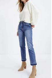 Blue cropped jeans with raw hem detail and a straight leg, styled with boots.