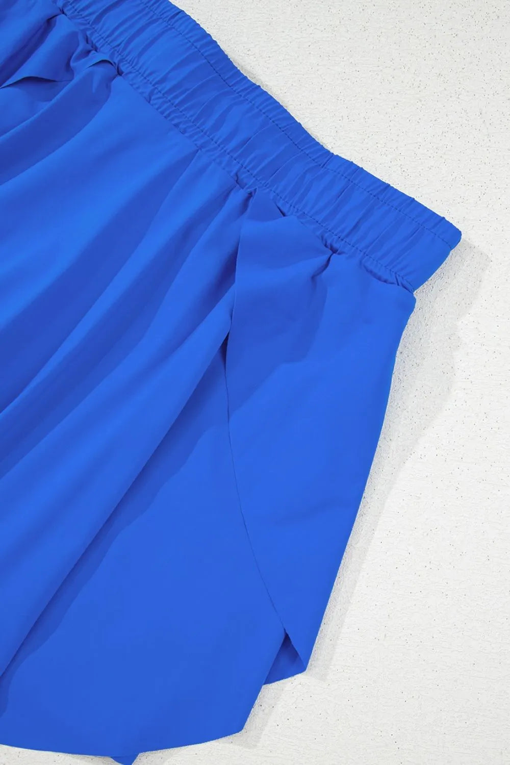 Blue flared skort with elastic waistband and tie detail.